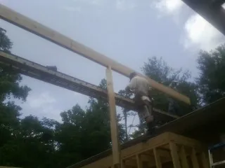 Carpenter setting a ridge beam over a new addition frame — Ice Dam Removal by Roofing Brothers in Mays Landing