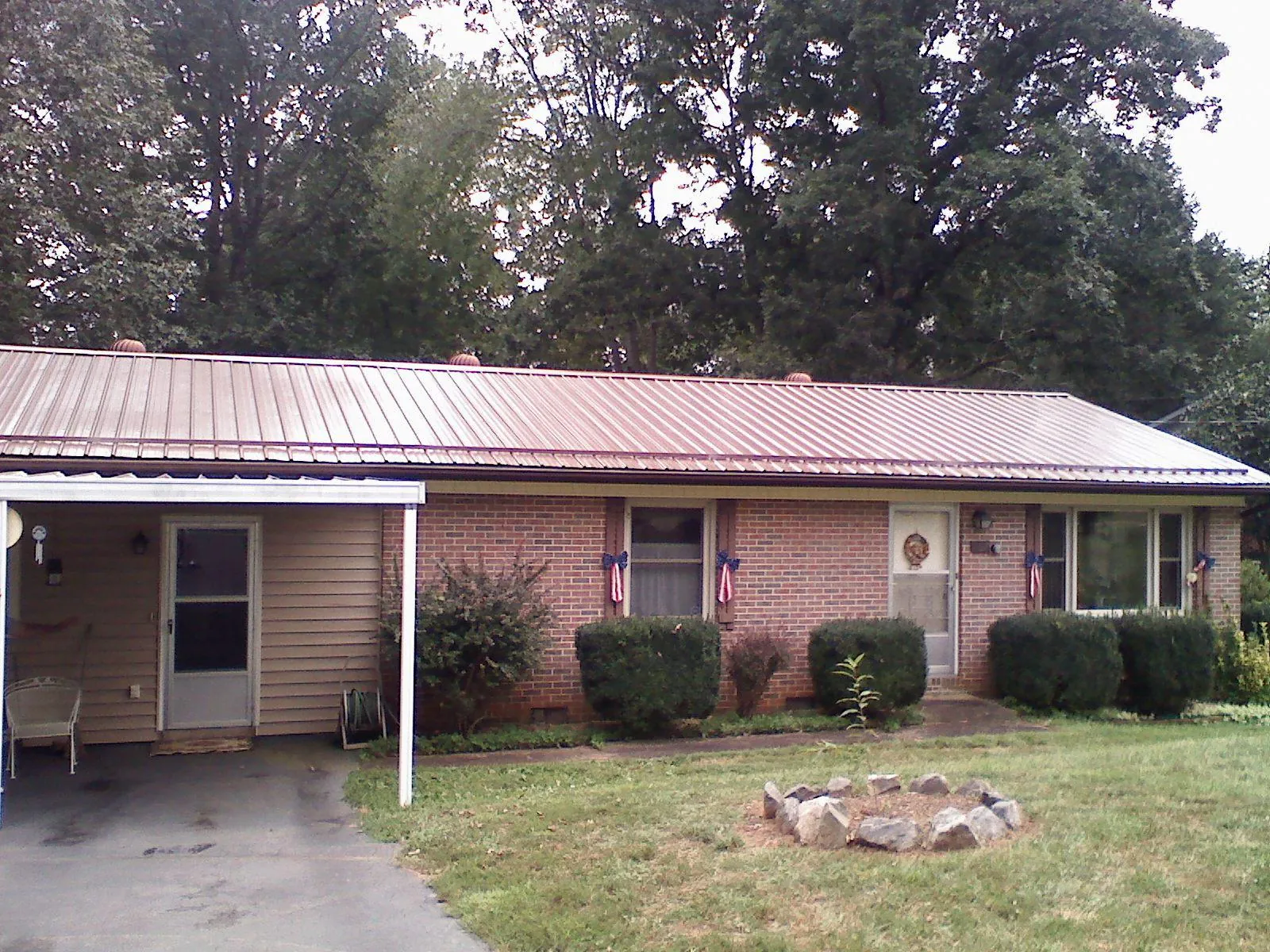 Bronze metal roof and carport on a brick ranch home — Roof Repair work by our crew in Mays Landing